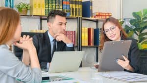 Business man and two women in meeting looking at chart