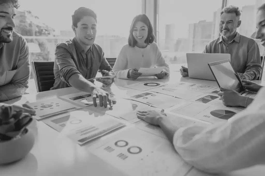 Black and white image of individuals holding meeting